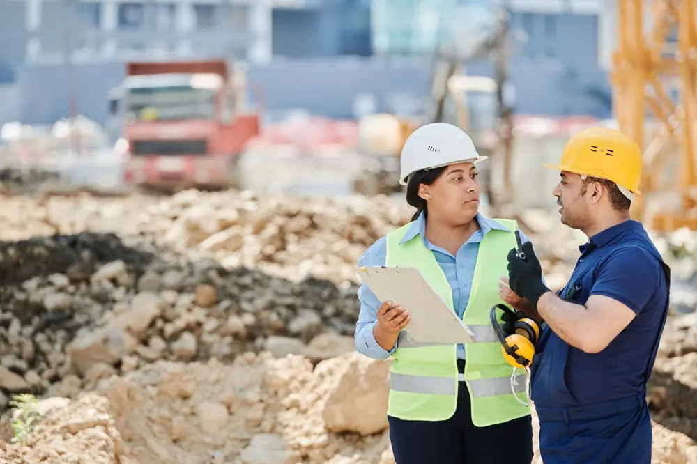 Trabajadores con casco y chaleco en una obra
